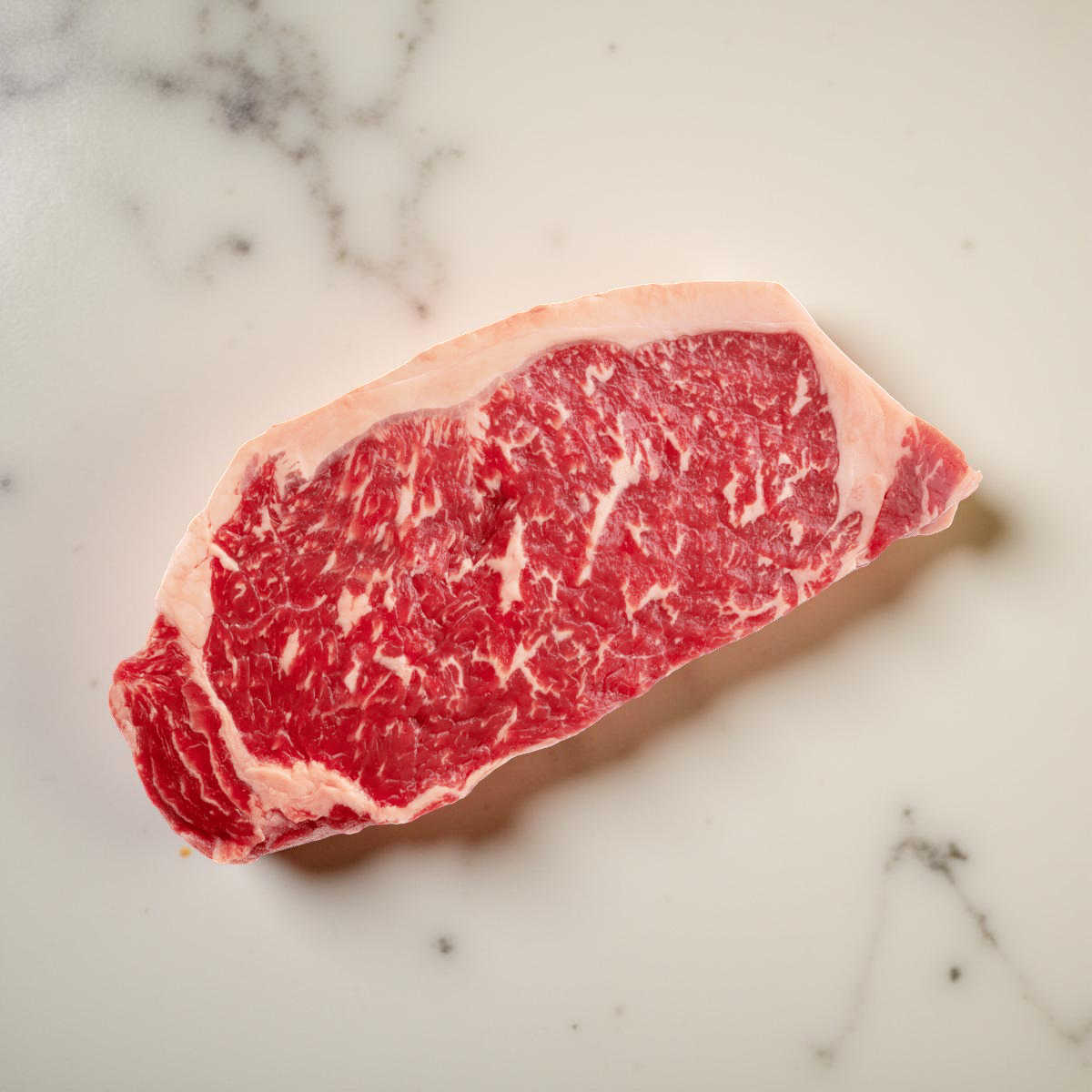21-day dry-aged New York Strip on white marble
